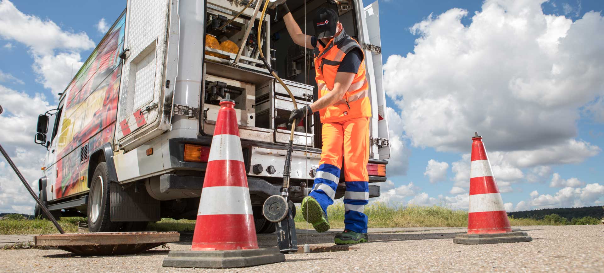 Kanalroboter wird mit Winde in Gulli herabgelassen